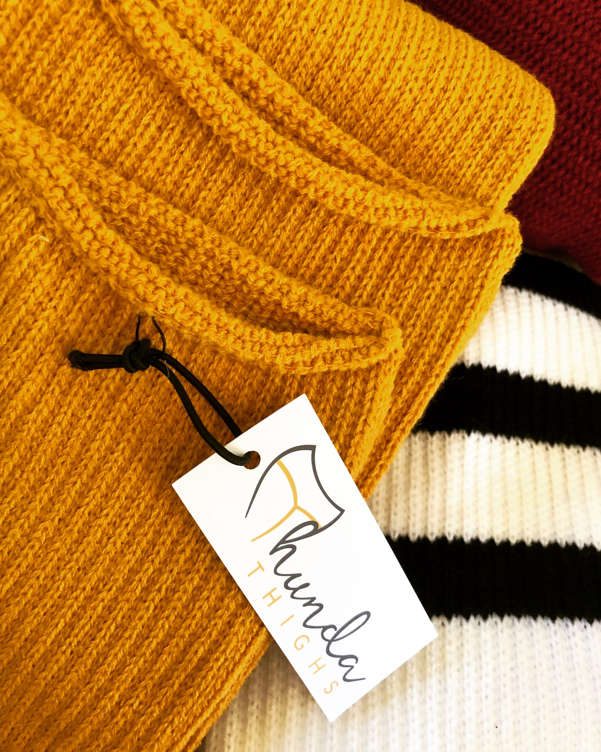 Image of gold, white, and burgandy plus size Thigh High socks from ThundaThighs.